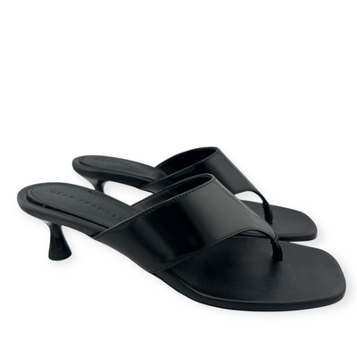 Elegant black heeled sandals with a glossy strap and toe loop design, featuring a slim kitten heel for a sleek look.